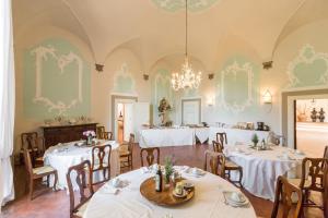 基安蒂盖奥勒Badia a Coltibuono Wine Resort & Spa的一间带桌椅和吊灯的用餐室