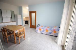 加利波利Appartamenti Rivabella D的厨房以及带桌子和床的用餐室。