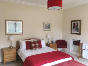 牛顿莫尔Netherwood House的一间卧室配有一张床和红色毯子