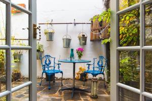 肯梅尔Cleo Gallery Apartments的庭院设有蓝色的椅子和鲜花桌。