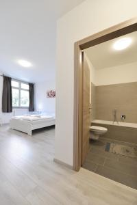 博尔扎诺Mary's Rooms & Apartments的带浴缸和卫生间的浴室以及1张床。