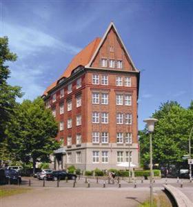汉堡普罗伊斯达姆图帕莱斯酒店的一座有尖顶的红砖大建筑