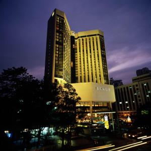 深圳深圳富临大酒店（近罗湖口岸和万象城和东门，提供限时升级特惠）的一座高大的建筑,前面有交通