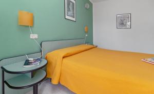 奥尔贝泰洛迷你酒店的一间卧室配有黄色的床和边桌