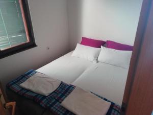 布德瓦apartman holiday budva的卧室配有带枕头的床铺和窗户。