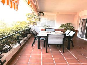 马贝拉Apartament Guadalmina的植物阳台的桌椅