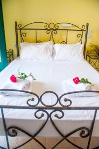 艾克索珀里斯Harma - Grand Sea & Mountains View的一张床上铺有白色床单和红色玫瑰