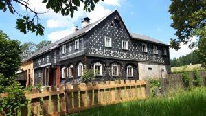 ŠluknovPrázdninový dům Nové Hraběcí的前面有木栅栏的黑色房子