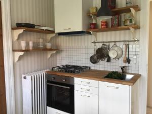 哥本哈根Villa Valby的厨房配有白色橱柜和炉灶烤箱。