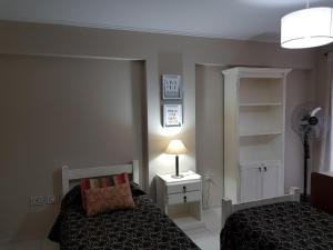 科尔多瓦Juventus的一间卧室配有一张床、一盏灯和风扇