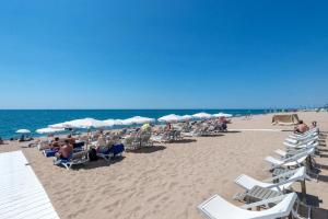 卡里拉Hotel Mar i Sol的海滩上的一组椅子和遮阳伞
