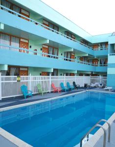 怀尔德伍德海滨度假村 的酒店前的游泳池配有椅子