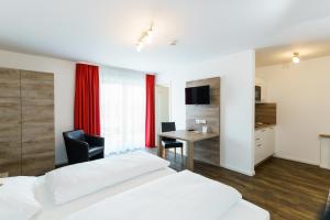 因戈尔施塔特康明茵酒店的一间卧室配有两张床、一张桌子和一张桌子