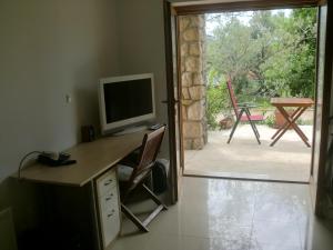 克尔克Villa Splendissima Krk - Adults only的客房设有一张书桌、一台电视和滑动玻璃门