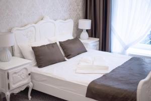 马尔堡Premium - Bed & Breakfast的卧室配有白色的床、两张桌子和一扇窗户