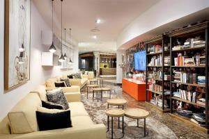 托尔托萨托尔托萨科罗娜SB酒店的带沙发、桌子和书籍的图书馆