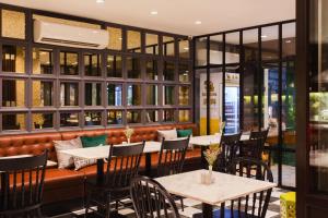 曼谷东方遗产公寓的一间带桌椅和长凳的餐厅