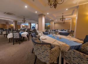 利隆圭太阳鸟首都酒店的一间在房间内配有桌椅的餐厅