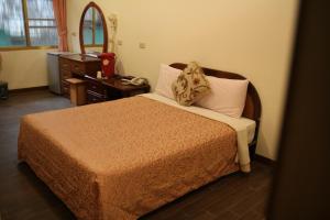 白河清秀旅社的一间卧室配有一张带梳妆台和镜子的床