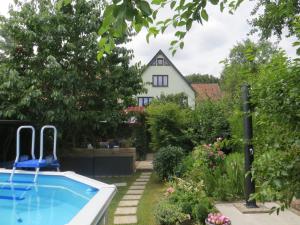 巴特利本施泰因Ferienwohnung "Waldblick"的一个带游泳池和房子的后院