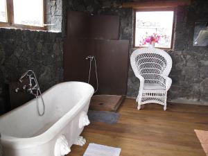 阿索马达拉杰里亚之家度假屋的一间带白色浴缸和椅子的浴室