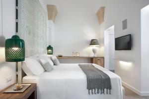 莱切曼塔特鲁尔酒店的白色卧室配有白色的床和绿灯