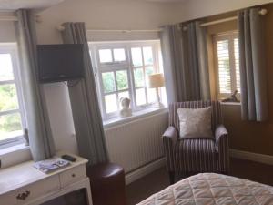 南特威奇The Swan Inn的卧室配有床、椅子和窗户。