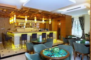 居姆贝特Royal Asarlik Beach Hotel的一间带桌椅的餐厅和一间酒吧