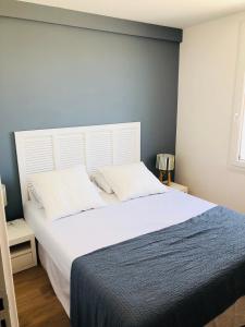 梅尔维尔弗朗瑟维尔普拉格Bel Appartement vue mer的一间卧室配有一张带白色床头板的大床