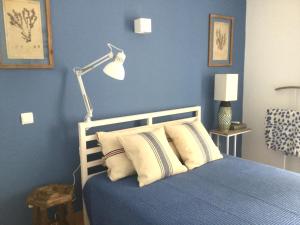 博利凯梅Yellow House - Checkinhome的蓝色卧室,配有床和灯