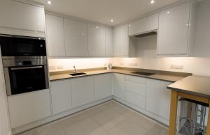 爱丁堡Gillespie House的白色的厨房配有白色橱柜和水槽