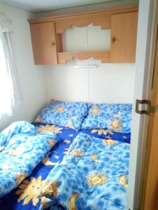 索博特卡Ubytovani v mobilnim domku的一张带蓝色床罩的床,上面有鲜花