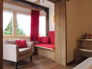 里茨勒恩阿潘松尼酒店的一间设有红色长凳和窗户的房间