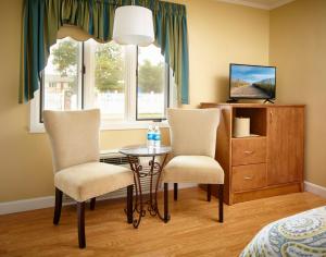 韦斯特利Breezeway Resort的一间卧室配有两把椅子、一张桌子和一台电视。