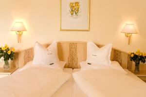 埃尔瓦尔德阿尔卑公馆度假酒店的酒店的客房内设有两张带白色枕头的床。