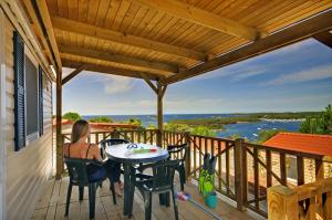 弗尔萨尔Orsera Camping Resort by Valamar的坐在房子甲板上桌子上的女人