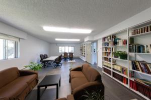 埃德蒙顿HI Edmonton - Hostel的客厅配有两张沙发和书架