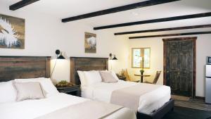 阿什福德天堂村酒店的卧室设有2张床和白色的墙壁。