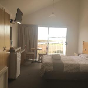 阿波罗湾辉煌海景汽车旅馆的酒店客房设有一张床和一个阳台。