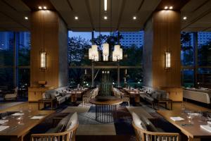 东京高轮大王子酒店的餐厅设有桌椅和大窗户。