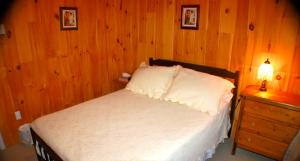 特里尼蒂三一套房公寓的一间卧室设有一张床和木墙