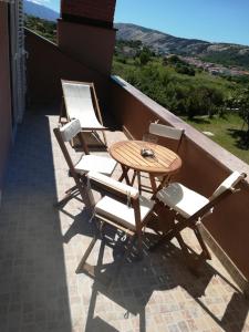 洛帕Apartments Mestrovic的阳台配有3把椅子和1张桌子
