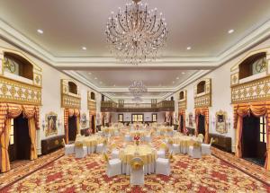 穆索里Welcomhotel by ITC Hotels, The Savoy, Mussoorie的一个带桌子和吊灯的大型宴会厅