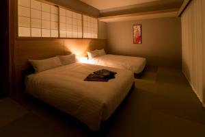 京都麦K之家酒店的酒店客房,设有两张床和一盏灯