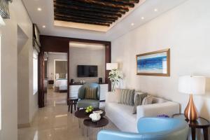 多哈Souq Al Wakra Hotel Qatar By Tivoli的客厅配有沙发、椅子和电视