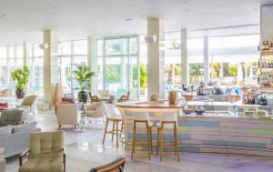 希贝尼克Amadria Park Beach Hotel Jure的餐厅设有桌椅和窗户。