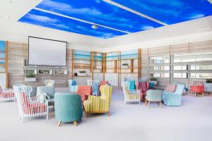 希贝尼克Amadria Park Beach Hotel Jure的一间设有五颜六色椅子和屏幕的等候室