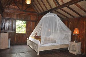 坎古库布迪尤玛巴厘岛别墅的一间卧室配有一张带蚊帐的床