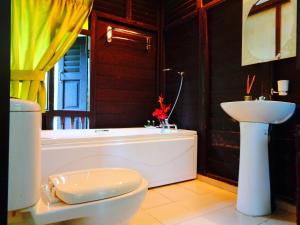瓜埠斯里乡村别墅的带浴缸、卫生间和盥洗盆的浴室
