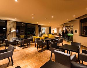 圣瓦伦蒂诺阿拉穆塔施托克尔酒店的餐厅设有桌椅,背景人员